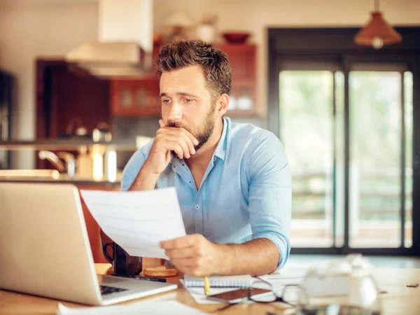un homme v&eacute;rifie ses relev&eacute;s bancaires