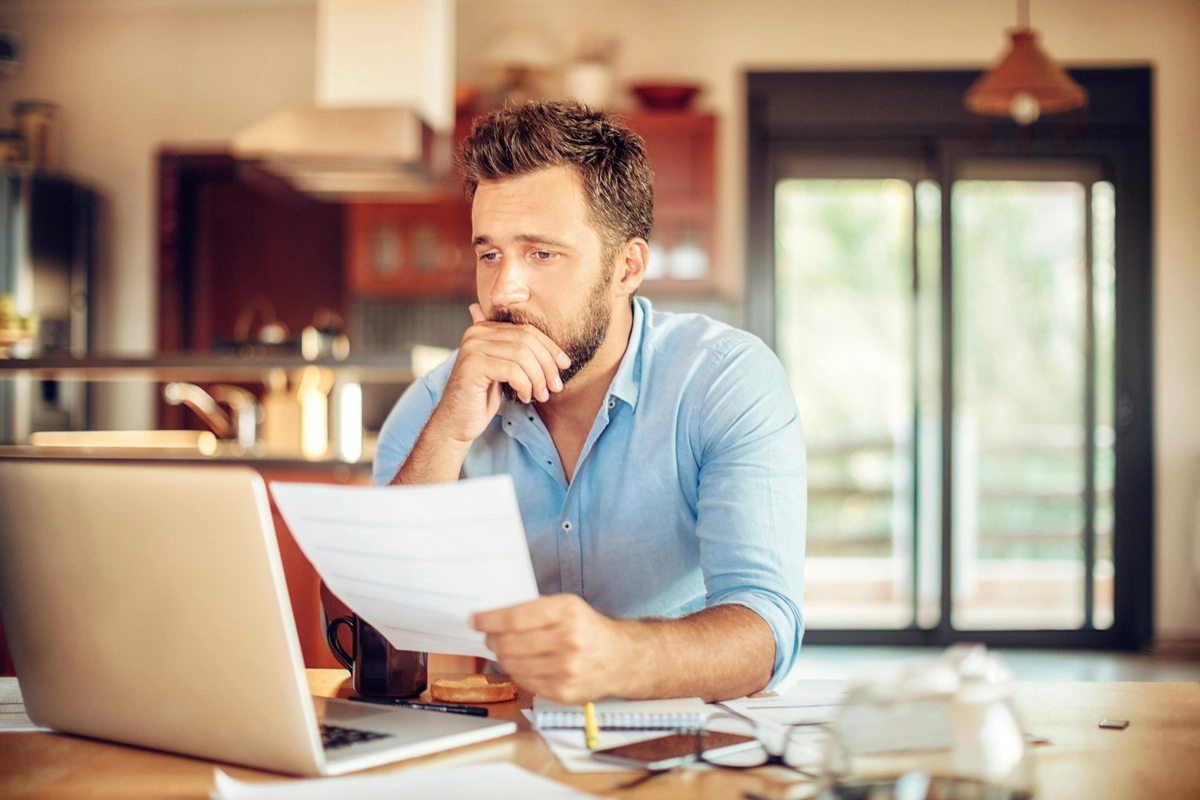 un homme v&eacute;rifie ses relev&eacute;s bancaires