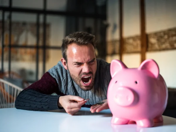 homme &eacute;nerv&eacute; avec sa tirelire